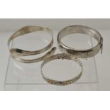 THREE HALLMARKED SILVER BRACELETS, one having applied gold flowers, combined weight; 65g