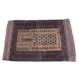 A MID-20TH CENTURY TURKISTAN WOVEN WOOLLEN PRAYER RUG, having central oatmeal field, dark plum