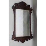 A 19TH CENTURY BEVELLED WALL MIRROR in fret cut frame, 86cm high