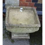 A SQUARE FORMED CAST CONCRETE GARDEN PEDESTAL PLANTER