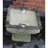 A SQUARE FORMED CAST CONCRETE GARDEN PEDESTAL PLANTER