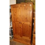 A MODERN PINE TWO DOOR WARDROBE fitted with a single shoe drawer