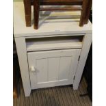 A WHITE PAINTED WOODEN SIDE CABINET with magazine recess over single door