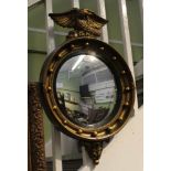 A REGENCY DESIGN GILT FRAMED CONVEX WALL MIRROR with ball frame and eagle crest, plate size; 28cm