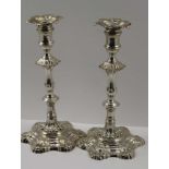 WILLIAM GRUNDY, A PAIR OF GEORGE II CAST SILVER CANDLESTICKS, petal shaped bases, with knopped stems