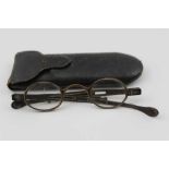 A PAIR OF GEORGE III SILVER FRAMED SPECTACLES, with adjustable side arms, small oval lenses, various