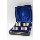 A CASE OF FOUR SILVER NAPKIN RINGS, three Birmingham 1925, one Chester 1925