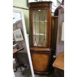 A REPRODUCTION YEW WOOD FINISHED FREESTANDING CORNER CUPBOARD