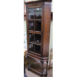 A MID-20TH CENTURY OAK FINISHED CORNER CUPBOARD ON STAND