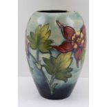 A MOORCROFT POTTERY VASE, tube lined and painted fuscia decoration on a tapering blue ground,