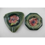 TWO MOORCROFT POTTERY ASHTRAYS, both tube lined and painted, one with hibiscus, the other with
