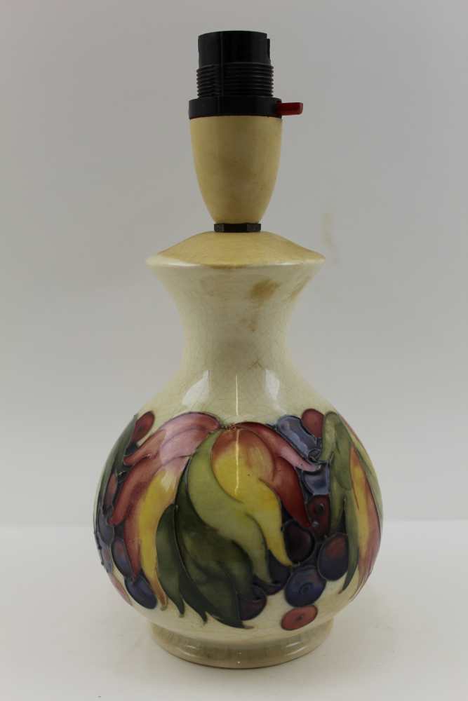 A MOORCROFT TABLE LAMP, tube lined and painted berries decoration on a cream ground, impressed