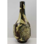 AN EARLY 20TH CENTURY POTTERY VASE OF BOTTLE FORM, impressed with three, green man type masks to the