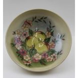 A MOORCROFT POTTERY FRUIT BOWL, tube lined and painted apples and blossom decoration, on a cream