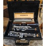 A CASED CLARINET together with a cased Hohner chromatic harmonica
