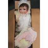 A BOX CONTAINING A PORCELAIN HEADED DOLL