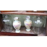 TWO GLASS DEMI JOHNS together with a pair of floral decorated pottery vases in the manor of Doulton