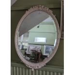 A LATER WHITE PAINTED FANCY FRAMED OVAL BEVEL PLATE WALL MIRROR