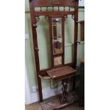 AN EARLY 20TH CENTURY OAK HALL STAND with central bevelled mirror plate, over probable Minton