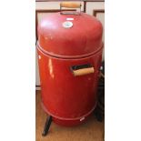 A RED FINISHED FREESTANDING CYLINDER SMOKER