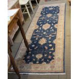 A PAKISTANI WOVEN WOOLLEN LONG RUG of Ziegler design, 244cm x 81cm