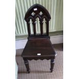 A LATE 19TH / EARLY 20TH CENTURY HALL CHAIR with ecclesiastical gothic design back over solid seat