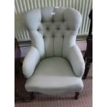 A SAGE GREEN TRELLIS UPHOLSTERED BUTTON BACK ARMCHAIR with serpentine fronted seat, supported on