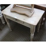 A LOW PINE SIDE TABLE fitted with a single central drawer, supported on short turned legs
