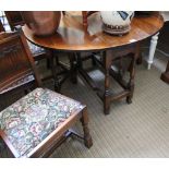 AN OLD CHARM BRANDED DINING SUITE, comprising gateleg table and four linen fold carved backed chairs
