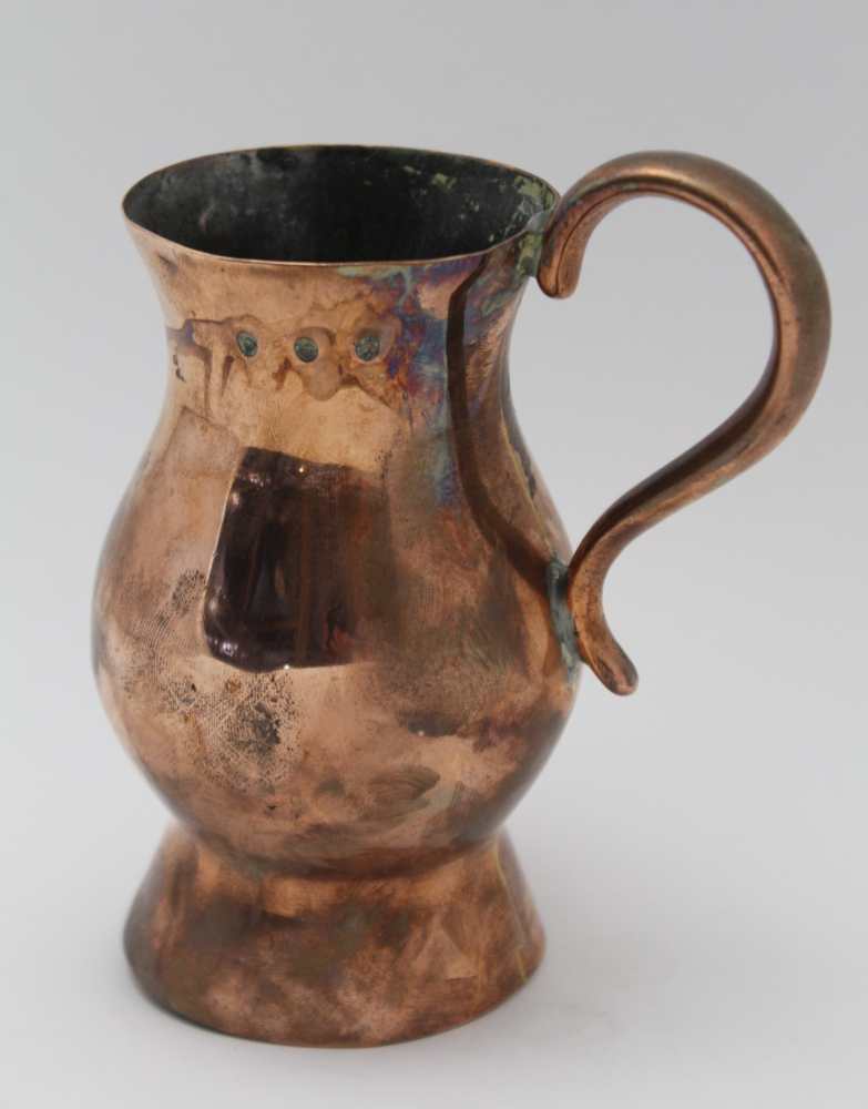 AN 18TH CENTURY COPPER TANKARD of baluster form, with scroll handle, raised on deep foot, height