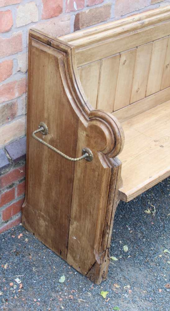 A 19TH CENTURY PINE FORMED TWO-SEATER PEW / SETTLE, having prayer book shelved back, on shaped plank - Image 2 of 3