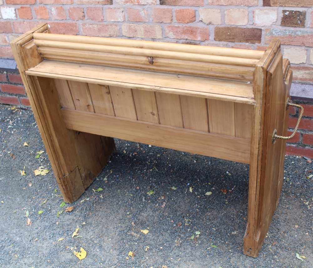 A 19TH CENTURY PINE FORMED TWO-SEATER PEW / SETTLE, having prayer book shelved back, on shaped plank - Image 3 of 3