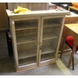 A STRIPPED PINE ADJUSTABLE SHELVED GLAZE DOORED BOOKCASE UNIT