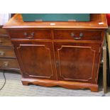 A REPRODUCTION YEW WOOD FINISHED SIDE UNIT having plain top with two inline drawers, over two