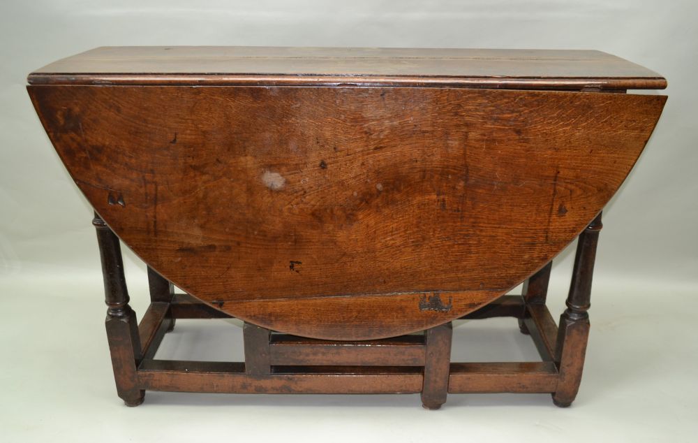 AN 18TH CENTURY OAK TWIN FLAP GATELEG DINING TABLE of oval form with opposing cutlery drawers,