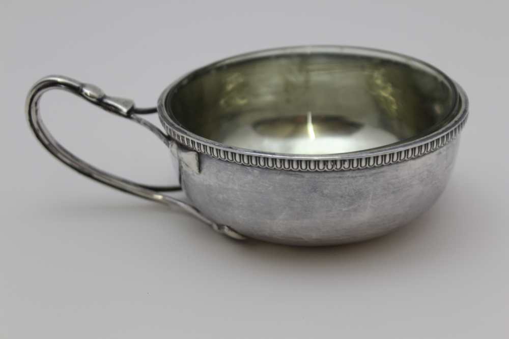 GUILD OF HANDICRAFT , A SINGLE HANDLED SILVER PORRINGER, planished bowl with egg & dart rim, the