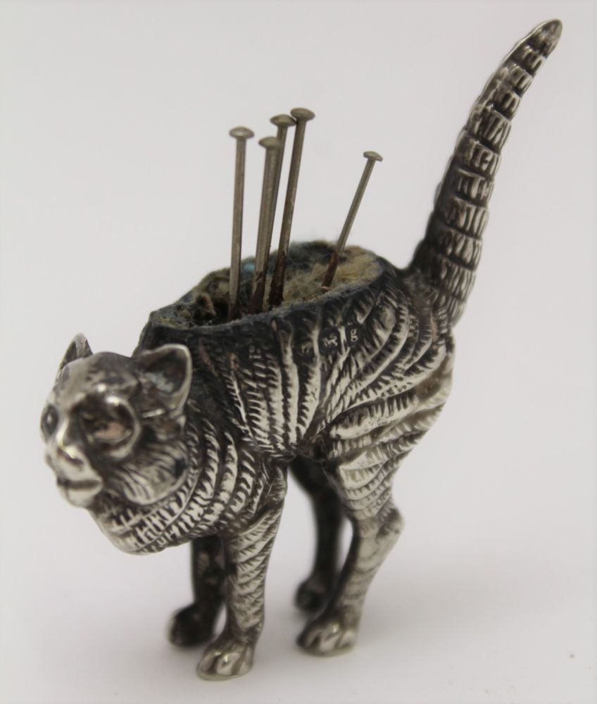 AN EDWARDIAN NOVELTY SILVER PIN CUSHION, modelled as an arch backed cat, by Levi and Salaman,