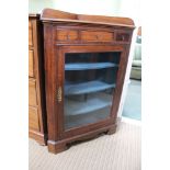 A FREESTANDING OAK CASED CORNER UNIT with plain glazed door revealing painted shelved interior