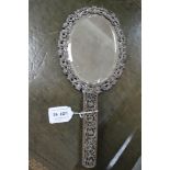 AN EARLY 20TH CENTURY CHINESE BRASS FILIGREE HAND VANITY MIRROR, fitted oval bevel plate, with worn,