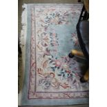 A TURQOUISE GROUND CHINESE WASHWOOL FLOOR RUG with floral decoration