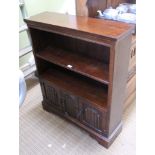 A REPRODUCTION OAK SET OF OPEN FRONTED SHELVES above two linen fold carved panelled cupboard doors
