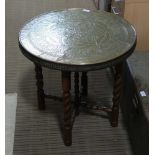 A MIDDLE EASTERN CHASED BRASS CIRCULAR TOPPED COFFEE TABLE on folding wooden base