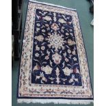 AN INDIAN WOVEN WOOLLEN FLOOR RUG, with floral stylised central field, and triple guard border
