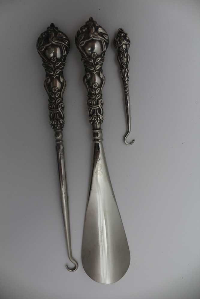 A CASED SILVER HANDLED SET, comprising shoehorn, boot & glove button hooks, embossed bird on a - Image 2 of 3