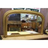 A LATE 19TH / EARLY 20TH CENTURY FANCY GILT FRAMED ARCH TOPPED PLAIN PLATE OVER MANTEL MIRROR