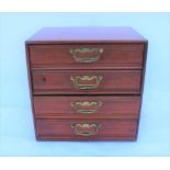 AN EDWARDIAN POLISHED WOOD FOUR DRAWER COLLECTOR'S CABINET, with brass handles, 31cm x 31cm