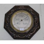 AN EDWARDIAN CARVED OCTAGONAL OAK FRAMED WALL BAROMETER, silvered dial, 36cm