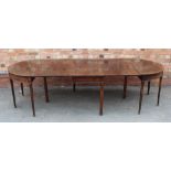 A GEORGIAN MAHOGANY DINING TABLE having twin plain D ends & twin flap central section, each