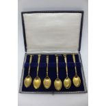 A CASED SET OF SIX SILVER GILT TEASPOONS, each terminal cast with a different sporting motif,