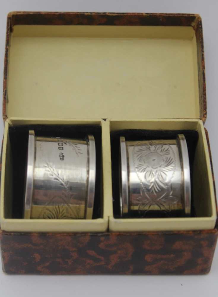 JOSEPH GLOSTER LTD A pair of silver napkin rings, floral chased decoration, Birmingham 1913, in a